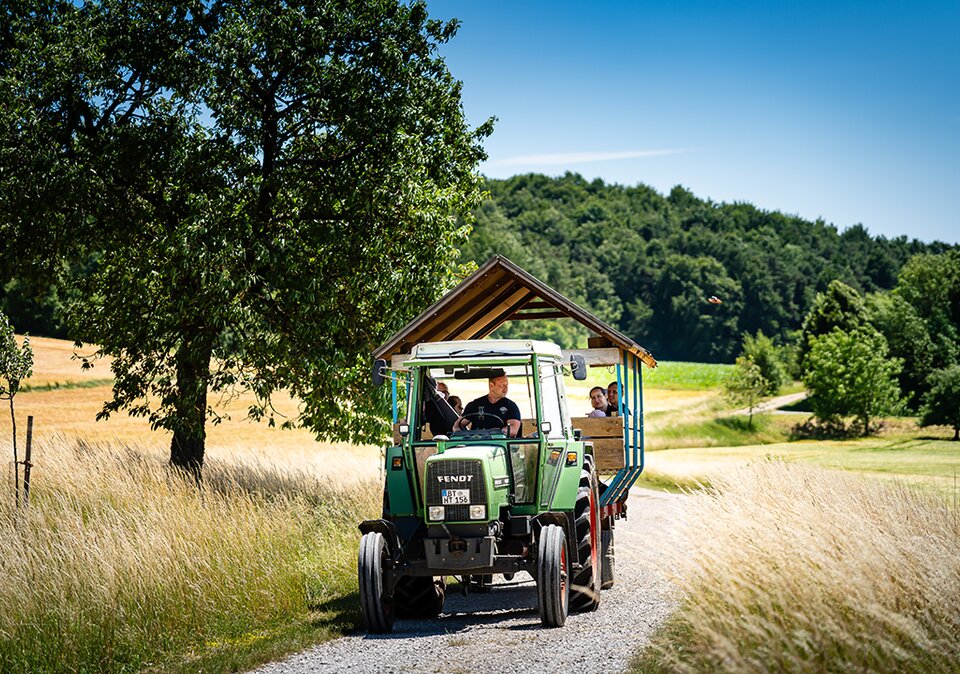 Familie bei einer Sparzierfahrt im Traktor-Anhänger Familie bei einer Sparzierfahrt im Traktor-Anhänger